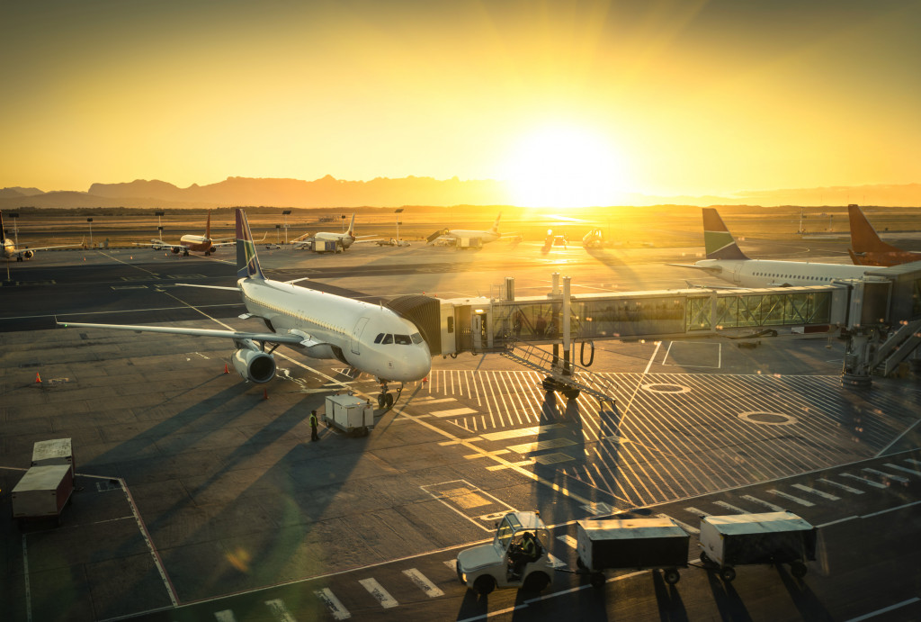 a parked white airplane and the sun sets in the background