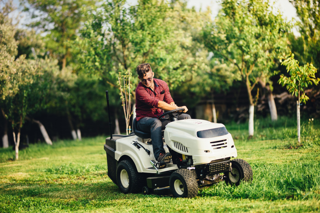 a man using a lawn mower to cut grass