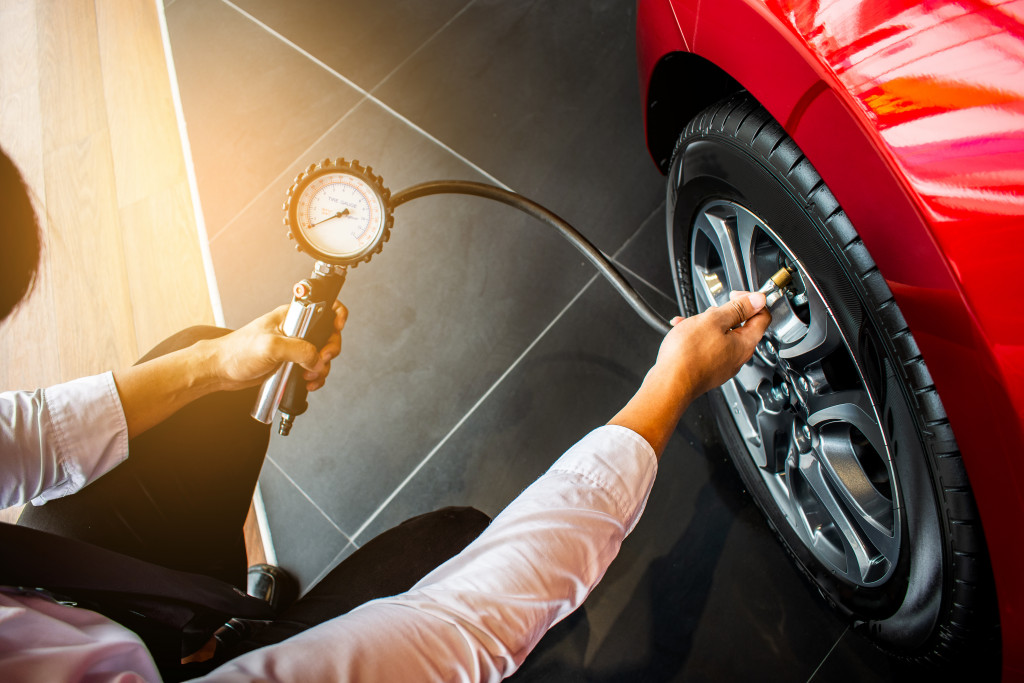 A person checking a car's tire pressure