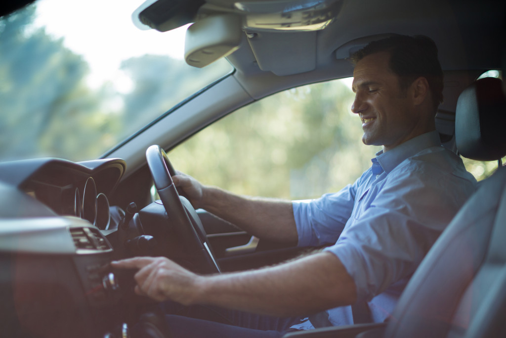 man smiling while driving car safely