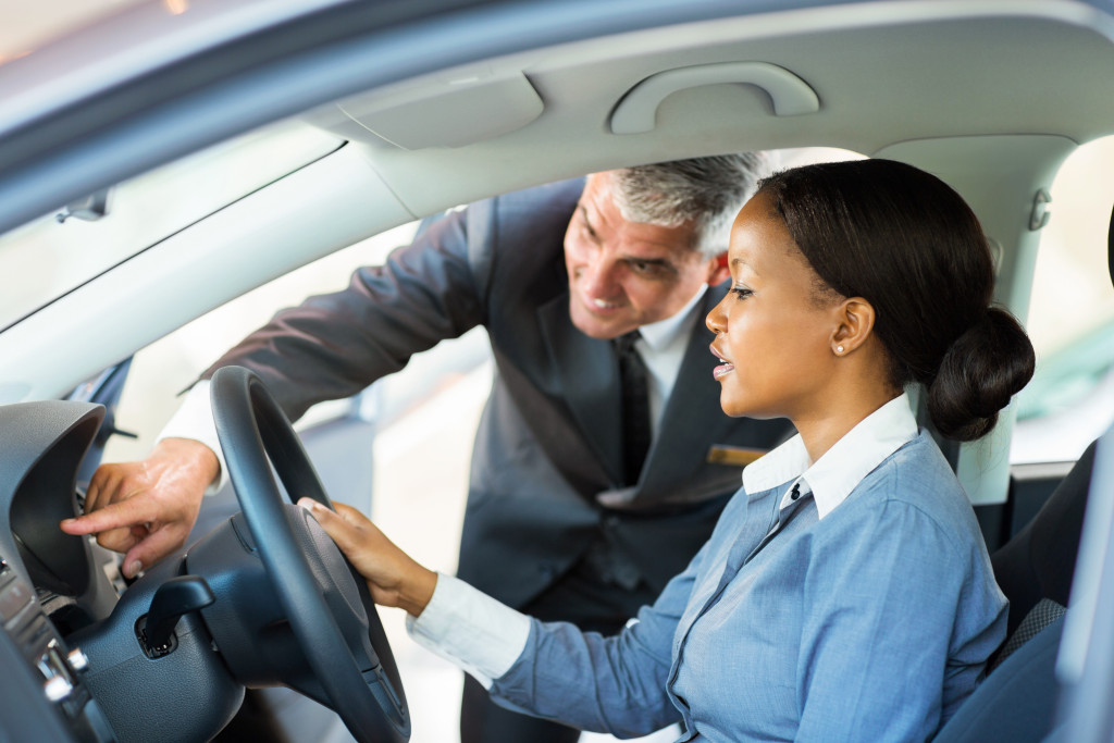 man showing vehicle features to a buyer