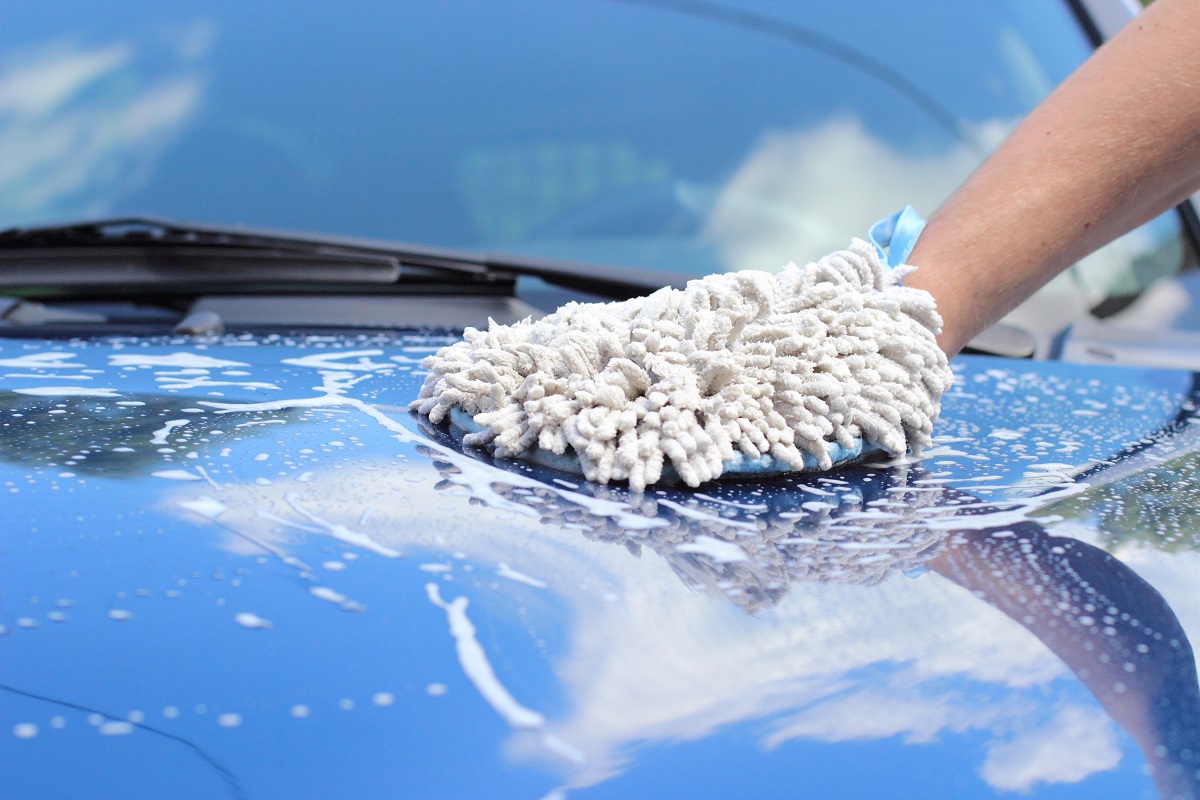 A worker washing a car