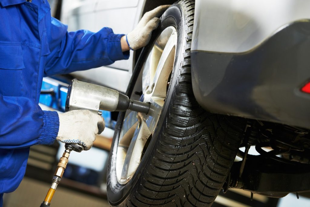 mechanic screwing car wheel