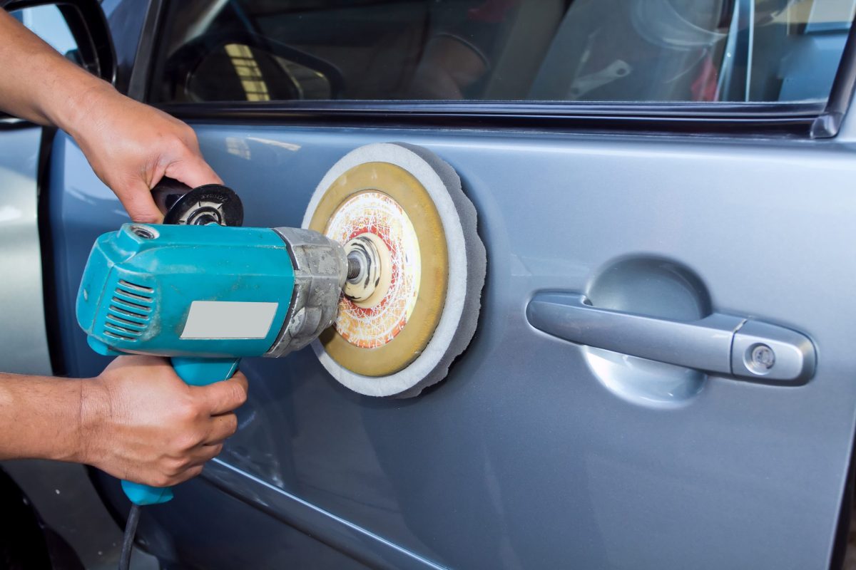 A worker polishing a car